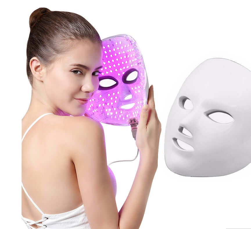 Woman using Led Facial beauty instrument with pink LED lights for skincare rejuvenation and treatment.